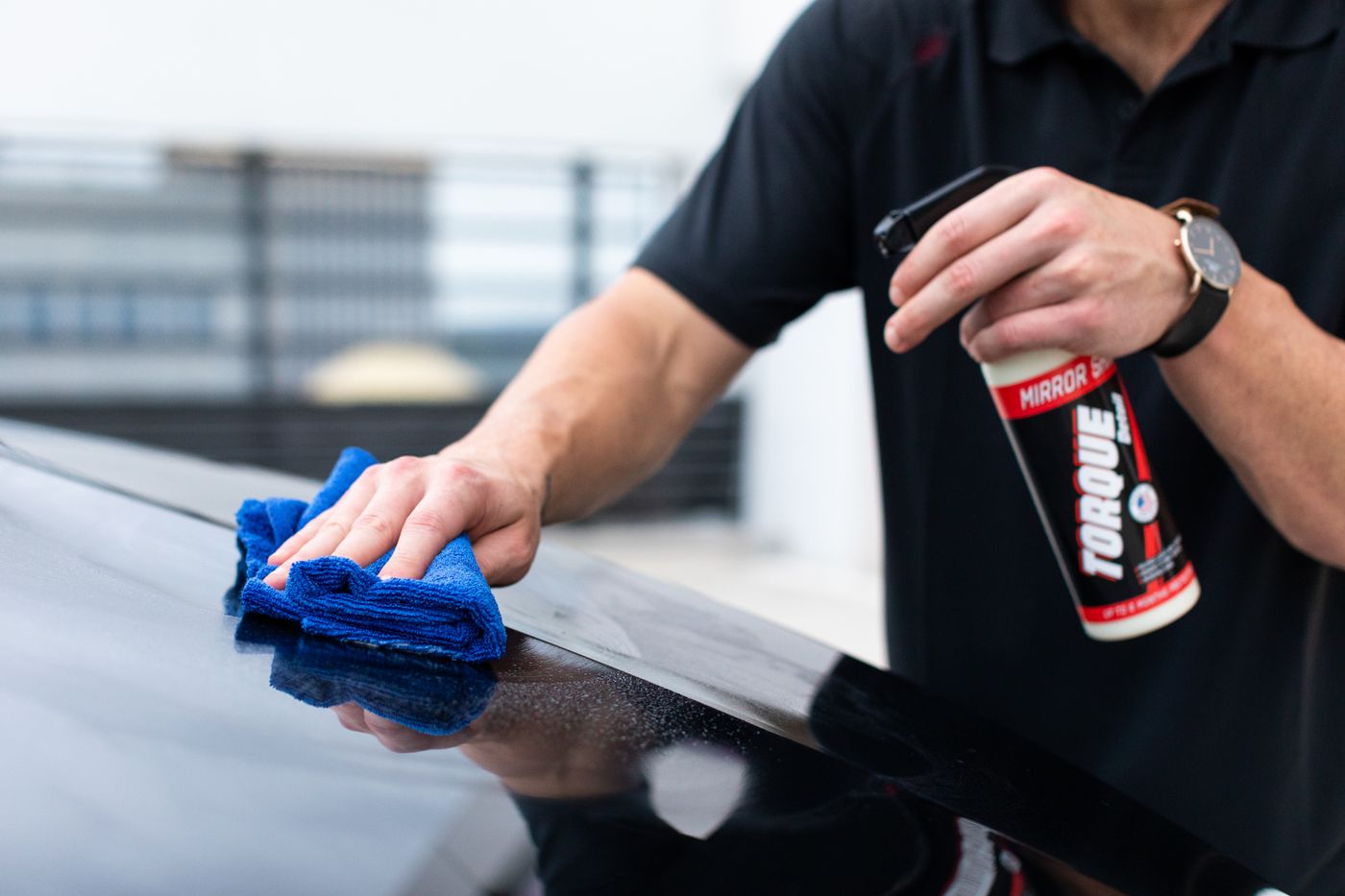 Comfort Auto Spa detailer hand-polishing a luxury car at a client's home